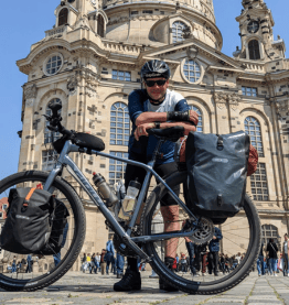 Mann lehnt an Dienstrad vor Sehenswürdigkeit Bikeleasing