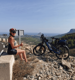 Frau macht Pause und parkt Dienstrad auf Berg Bikeleasing