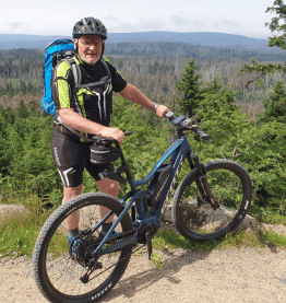 man standing next to bike in front of panorama bike leasing