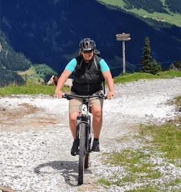 Lachende Frau auf Mountainbike Dienstrad in Berglandschaft