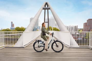 Lease a Bike Frau auf E-Bike vor Brücke