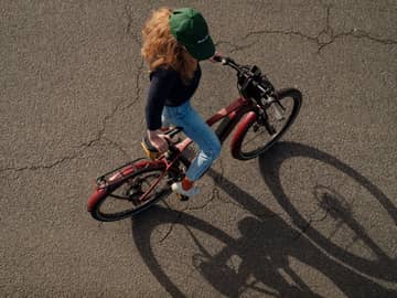 Lease a Bike Bikeleasing Woman with cap gets on red bike