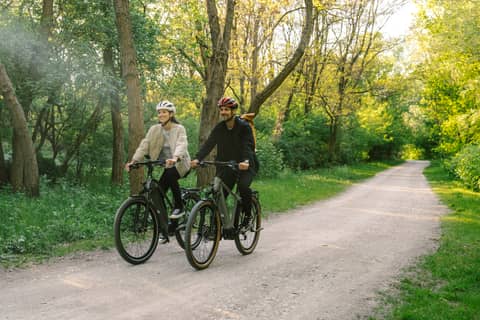 couple on bikes on bike path in forest