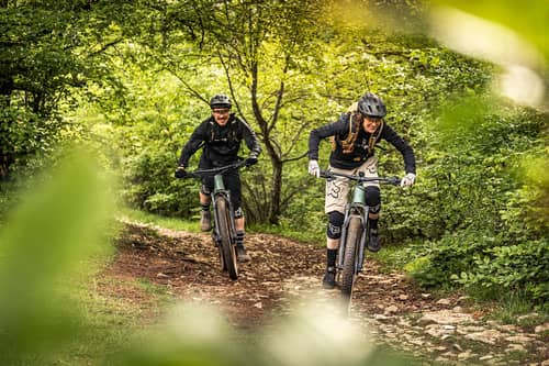 Man and woman on mountain bikes in the forest