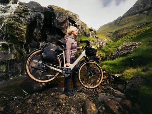 Frau trägt Fahrrad in Bergen