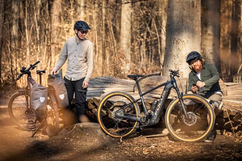 Two men with e-bikes in the forest
