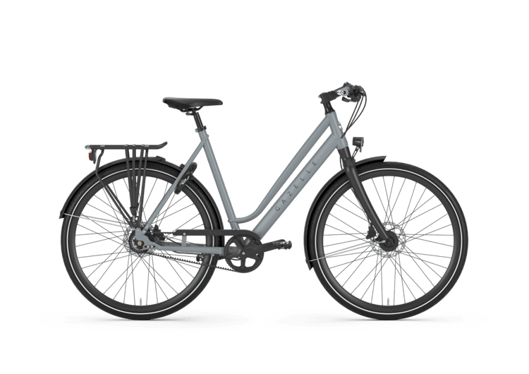 Graues Gazelle Marco Polo Urban Komfort Fahrrad mit Gepäckträger und Kettenschaltung vor grünem Hintergrund.