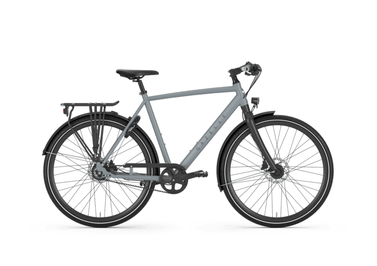 Graues Gazelle Marco Polo Urban Fahrrad mit Diamantrahmen, Gepäckträger und Kettenschutz auf grünem Hintergrund.