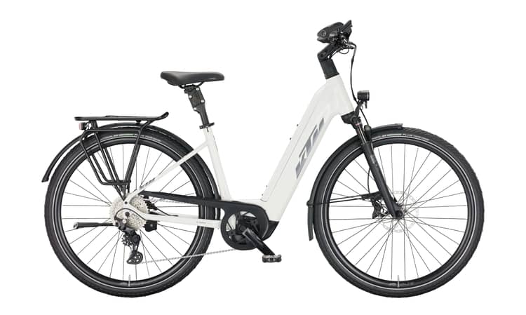 White and grey KTM Macina Style 720 electric bicycle with fenders and a rear rack on a white background.