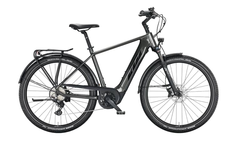 Trekking-E-Bike KTM Macina Gran 620 in Grau mit orangenen Akzenten, 51 cm Rahmenhöhe, profilierte Reifen und Gepäckträger.