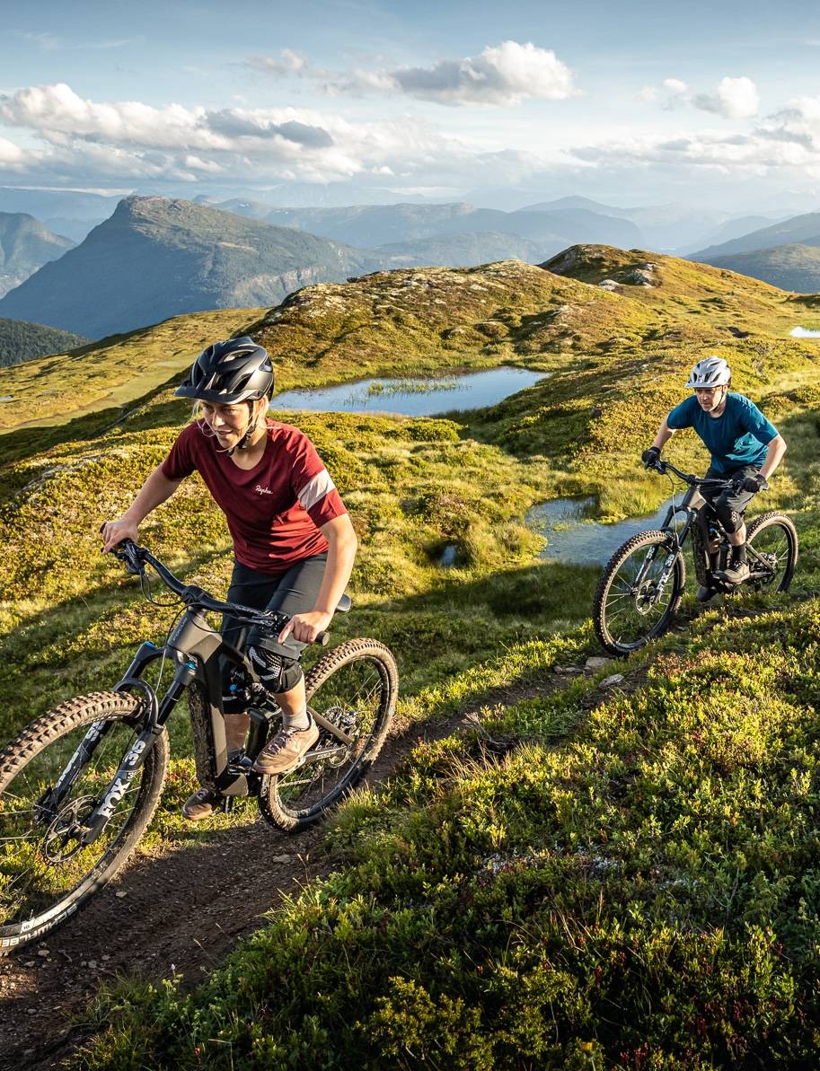two people on e-mountainbikes in mountain area driving up the hill