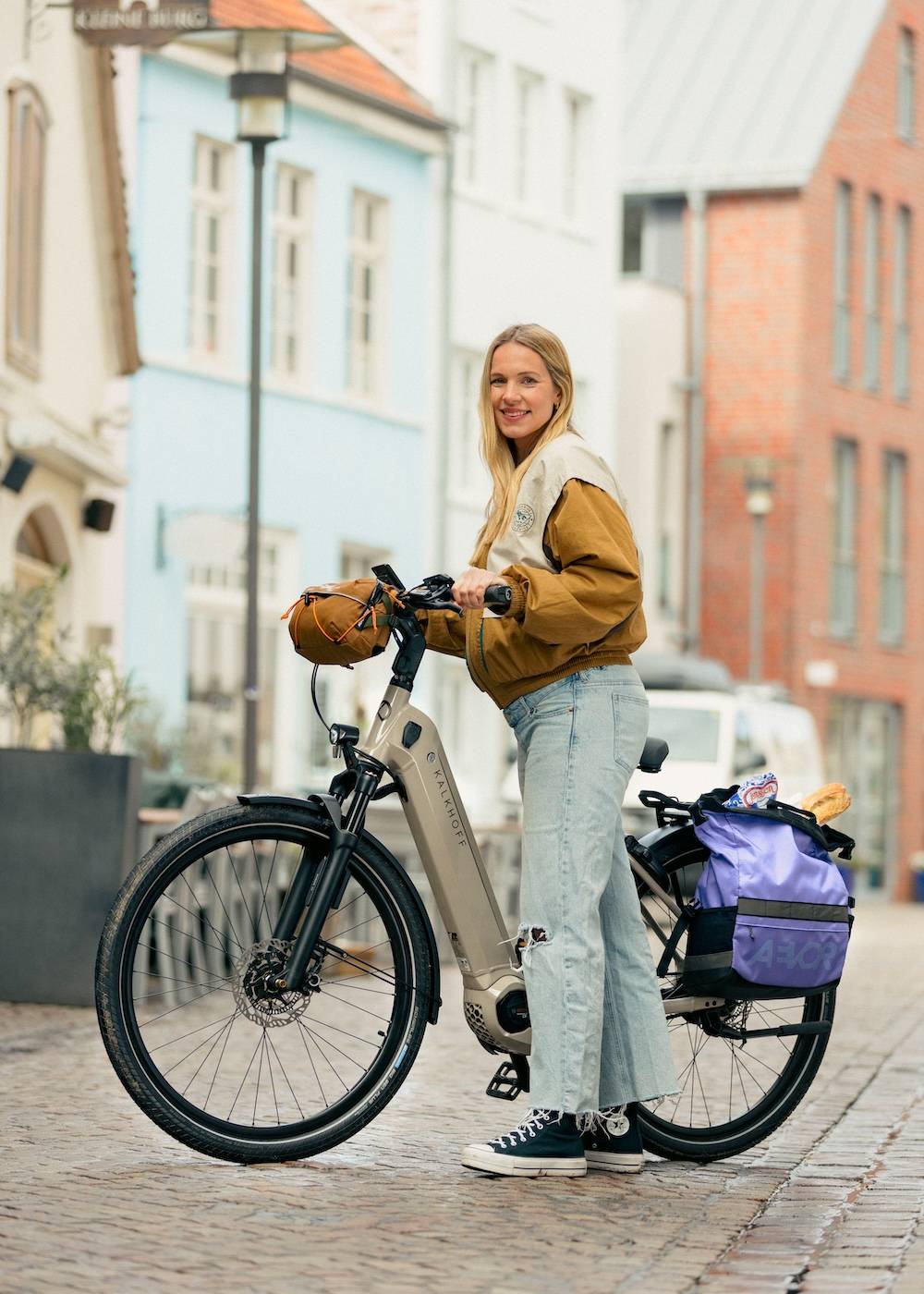 Young woman pushes e-bike through the city