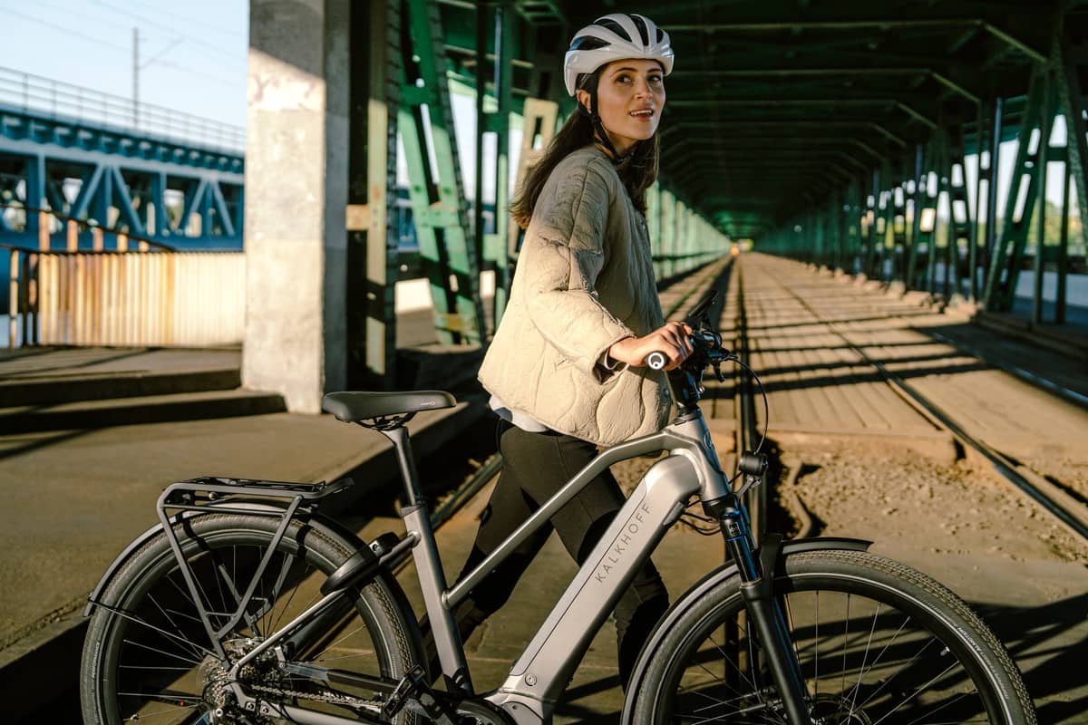 woman pushes Kalkhoff bike and looks into camera