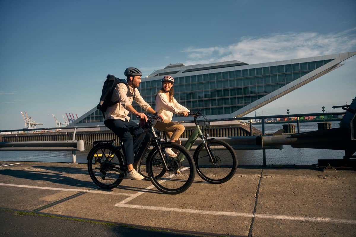 two people on bikes riding through city