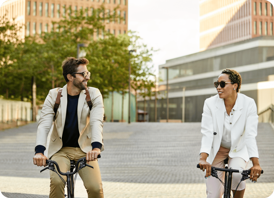 couple on bikes in urban surrounding smiling and looking at each other