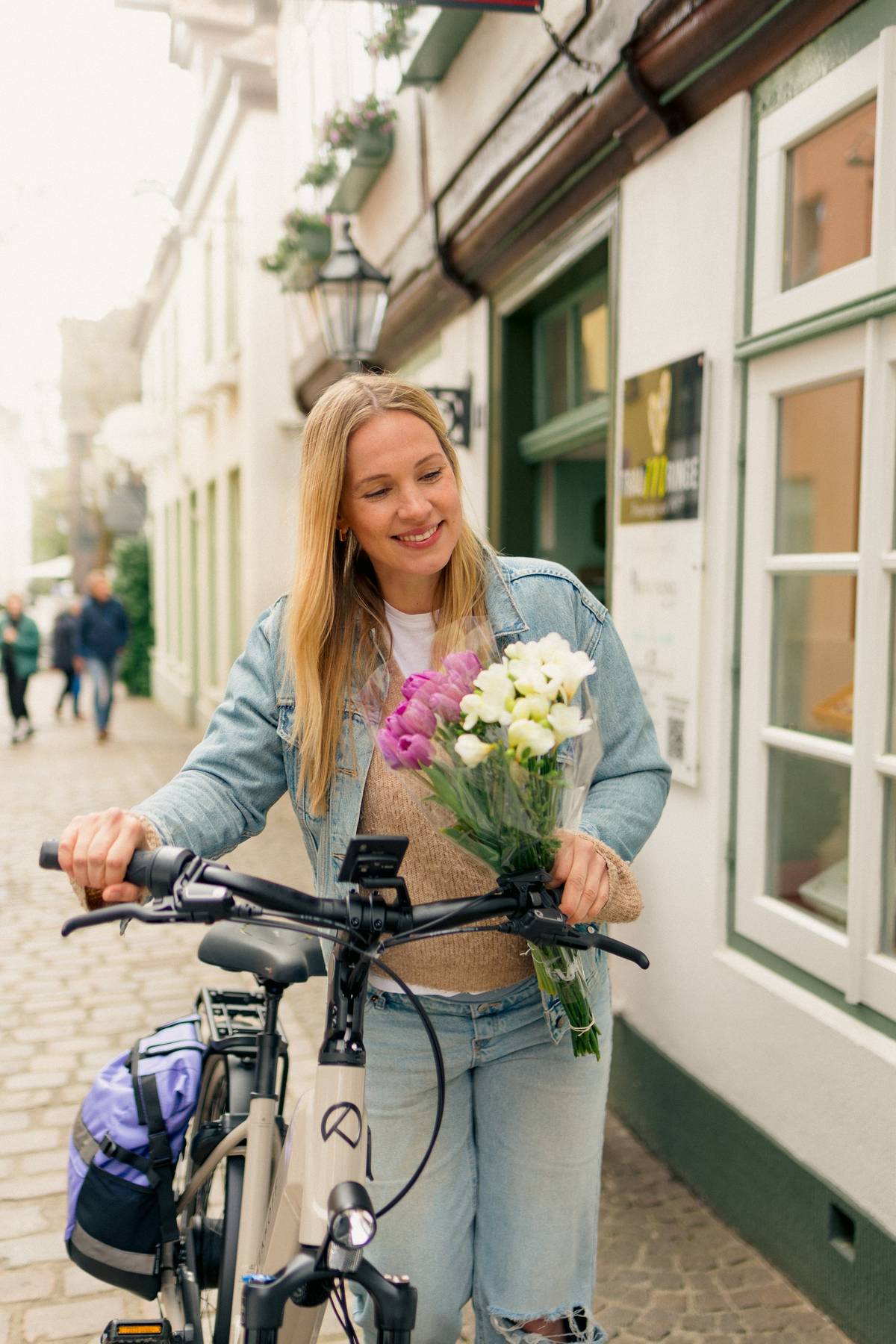 Frau mit Kalkhof Fahrrad und Blumenstrauß