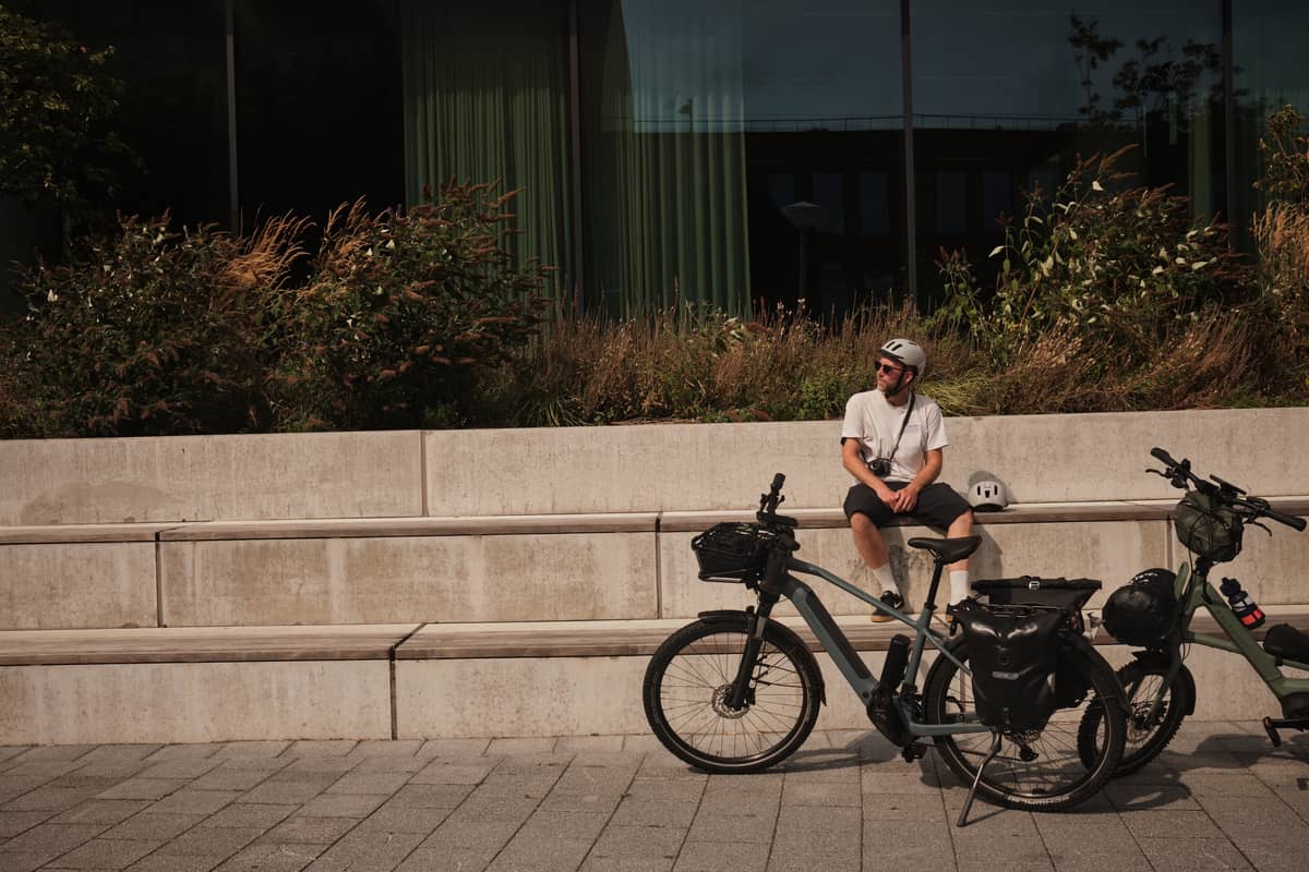 Man sitting on wall with bike in front of him