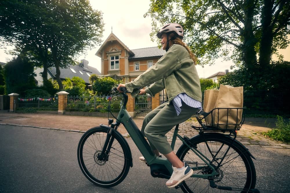 Woman on e-bike with shopping in basket