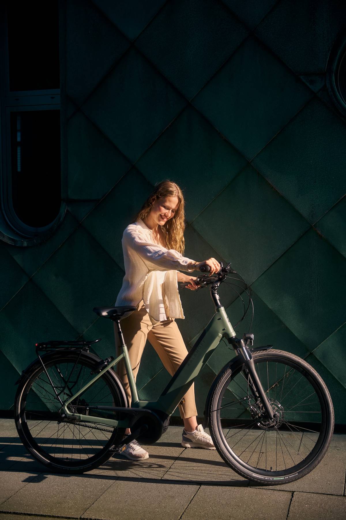 woman pushing her bike while smiling