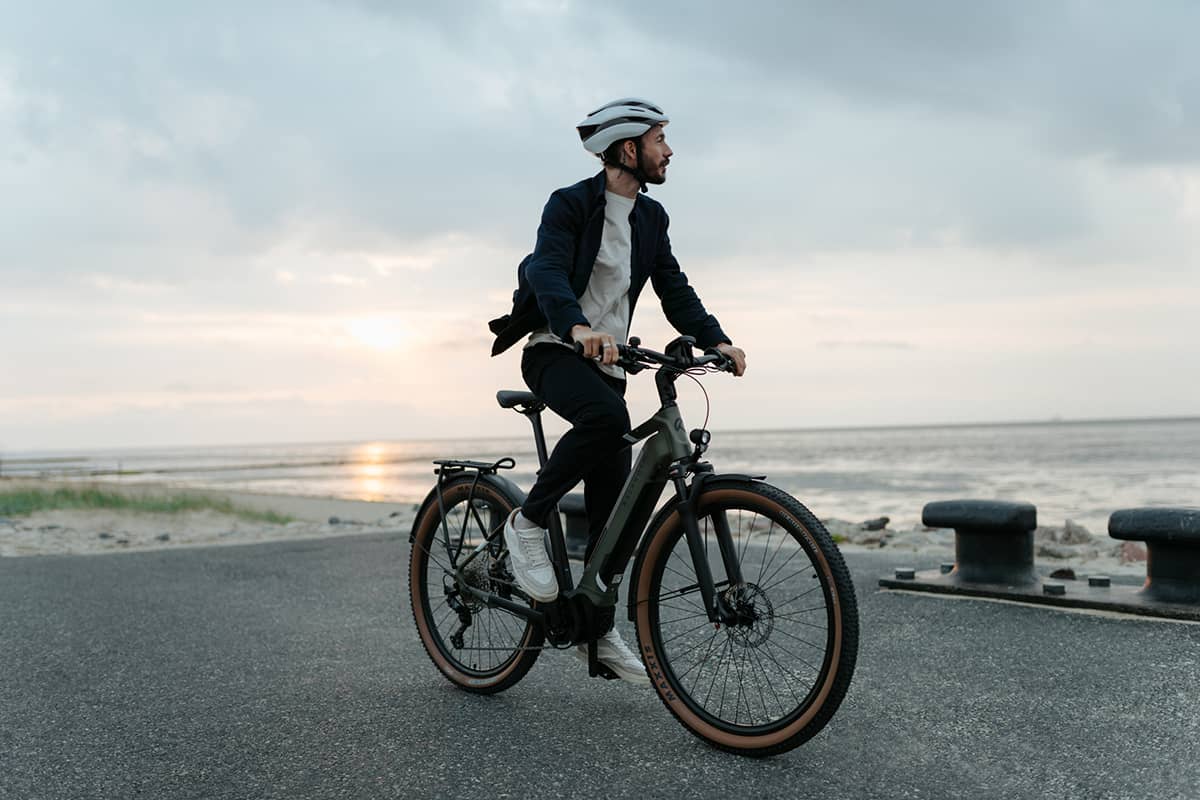 Lease A Bike Mann mit Fahrrad blickt auf Strand