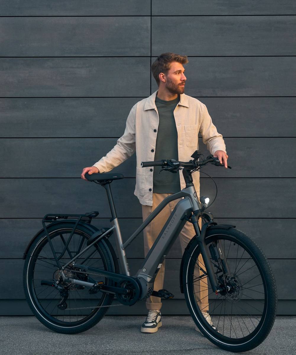 Young man standing next to his e-bike