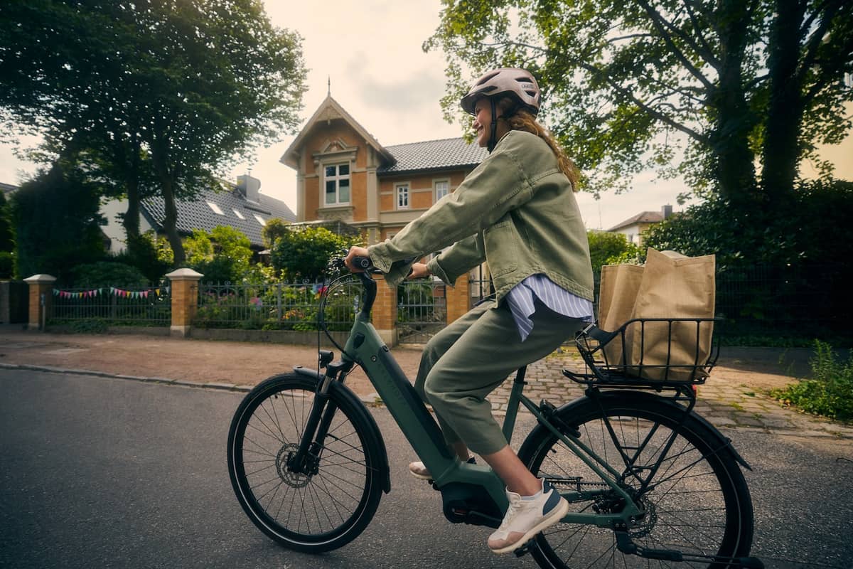 Frau fährt mit Kalkhoff Fahrrad in Siedlung