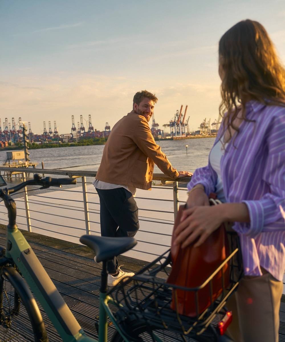 Man and woman standing with e-bike at the Landungsbrücken in Hamburg