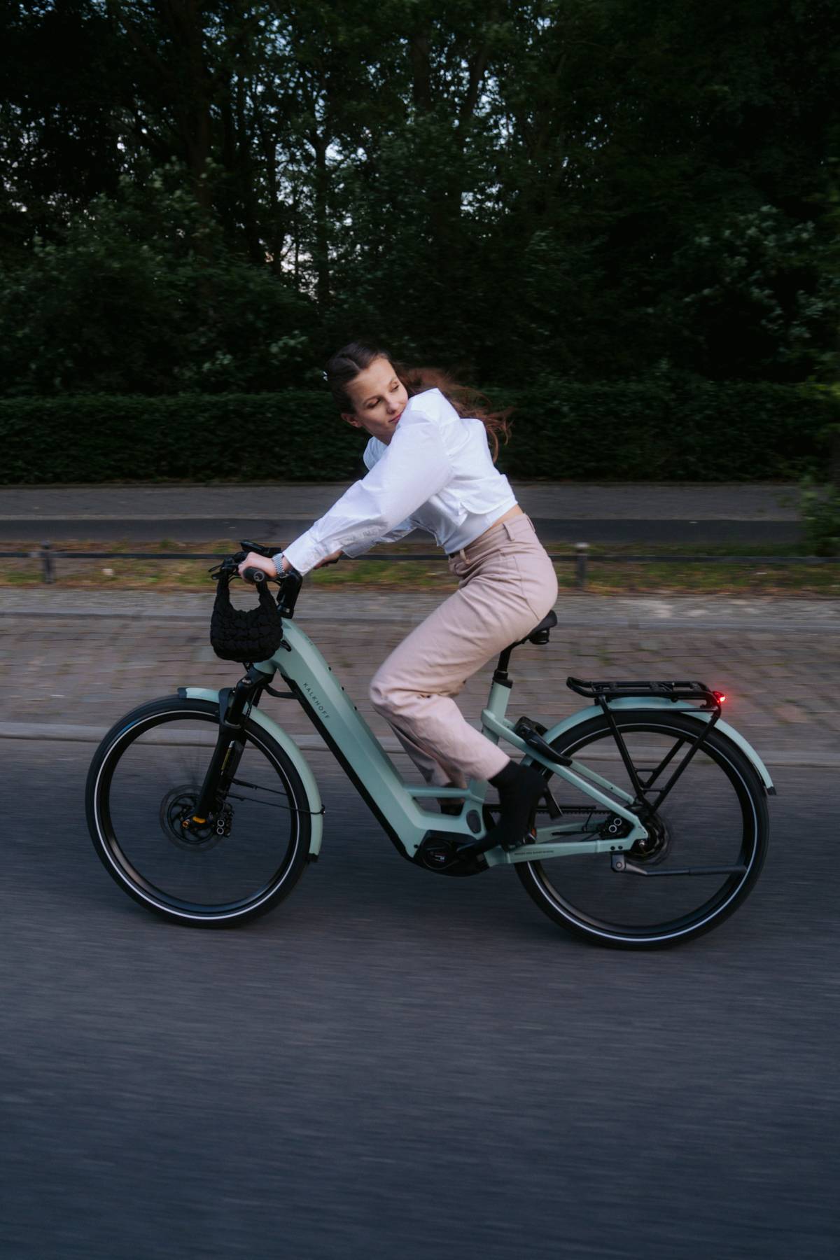 sustainable mobility woman sitting on bike and looking to the back while driving